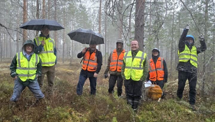 OGCR-hankkeen maastokäynnillä Vermassalossa mukana olleet henkilöt yhteiskuvassa metsäympäristössä sadekelissä.
